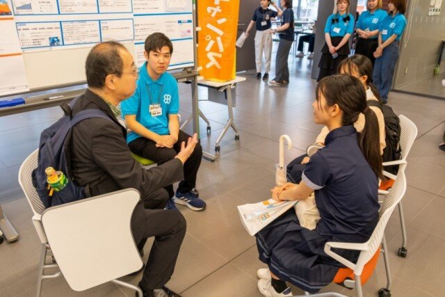 ゼミやサークルのポスターを展示したエリアで、本学教員や学生から直接、話を聴く様子