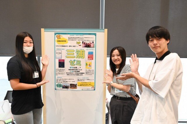 ゼミのポスターを展示したパネル前の学生たち