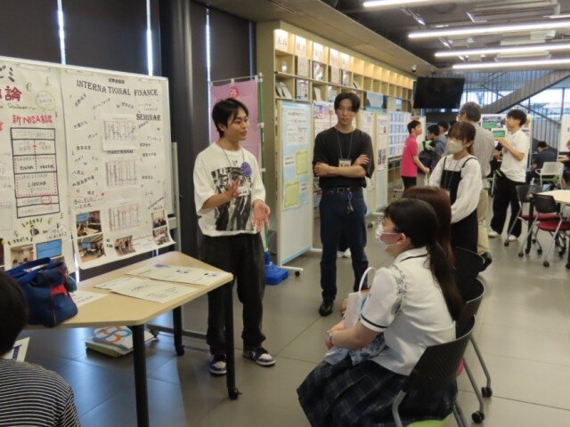 ゼミやサークルのポスターを展示したエリアで、本学教員や学生から直接、話を聴く様子